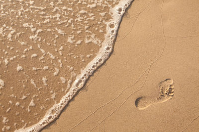 Close-up of footprints on sand at beach