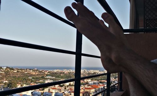 Close-up of hand against railing in city