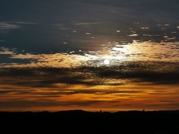 Scenic view of silhouette mountains against orange sky