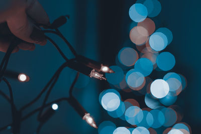 Close-up of hand holding illuminated lighting equipment