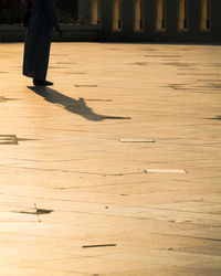 Low section of person standing on wooden floor