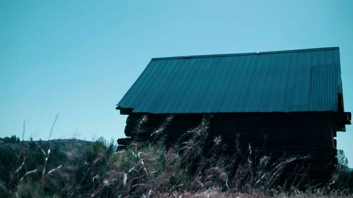 Built structure on landscape against clear blue sky