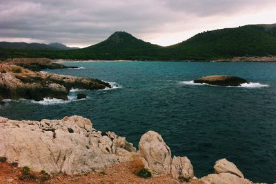 Scenic view of mountains against cloudy sky