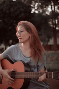 Woman playing guitar in the park