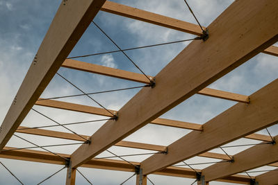 Detail of a modern wooden architecture in glued laminated timber on a blue cloudy sky