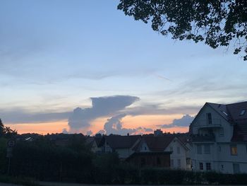 Houses in town against sky during sunset