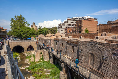 Arch bridge in city against sky