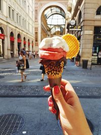 Midsection of woman holding ice cream in city