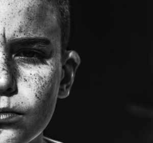 Close-up portrait of man against black background