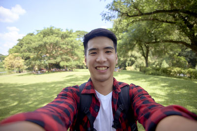 Portrait of smiling young man against plants