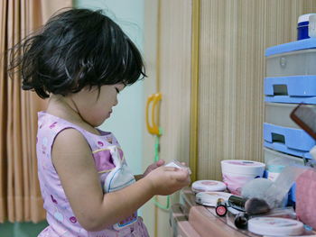 Side view of cute girl standing at home