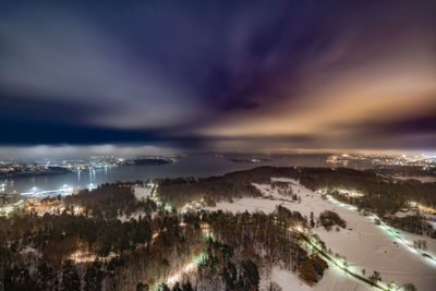 Panoramic view of illuminated city against sky at sunset