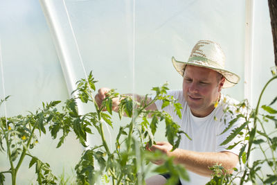 Man wearing hat against plants