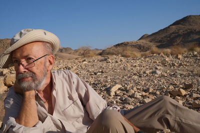 Portrait of senior man sitting at beach
