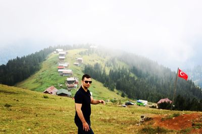 Man standing by turkish flag on mountain