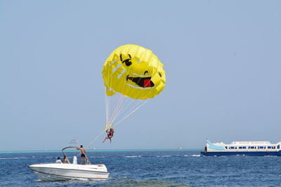 Friends on boat in sea against clear blue sky