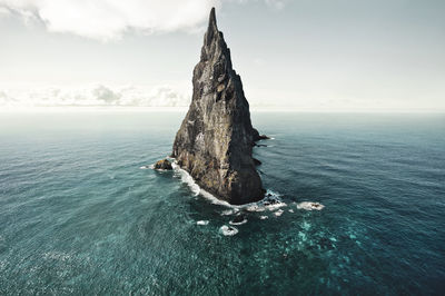 Rock formation in sea against sky