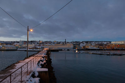 Bridge over river against cloudy sky