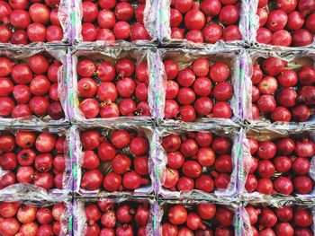 Full frame shot of pomegranates in containers at market for sale