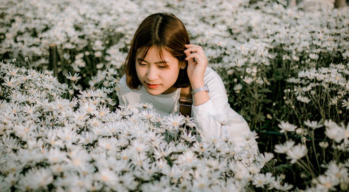 Portrait of a woman on white flowering plants