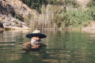 Bearded man bathing and relaxing in the river. person