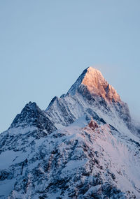 Scenic view of snowcapped schreckhorn mountain against clear blue sky