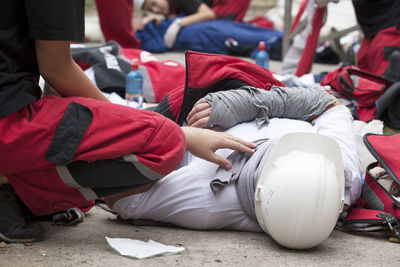 Paramedic performing cpr on person lying on street