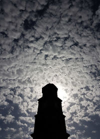 Low angle view of silhouette cross against sky