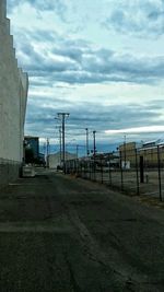 Empty road against cloudy sky
