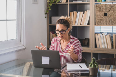 Woman using laptop while sitting at home