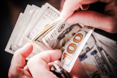 Close-up of person counting paper currency