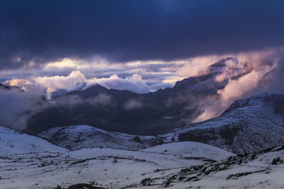 Snow covered landscape against clouds