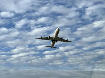 Low angle view of airplane flying against sky