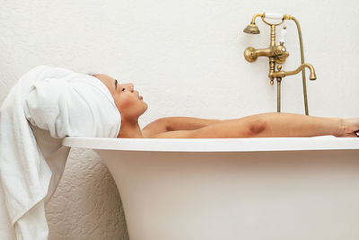 Woman relaxing in bathtub at bathroom