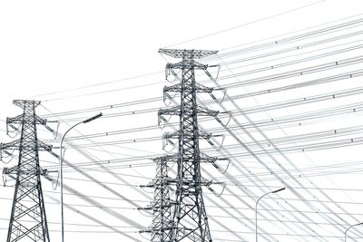 Low angle view of electricity pylon against clear sky