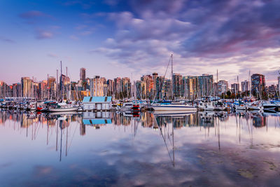 Boats moored at harbor against sky