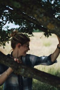 Smiling young woman holding tree branches