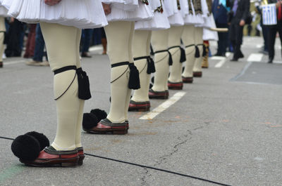 Low section of people walking on street during green independence day parade in new york city.