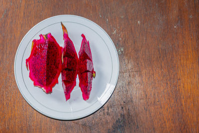 High angle view of red fruits in plate on table