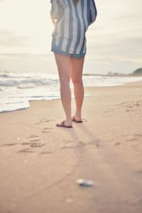 Low section of woman standing on beach