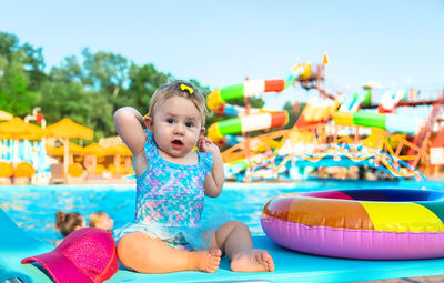 Portrait of cute baby girl sitting on inflatable ring
