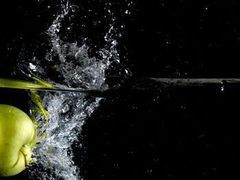 Person splashing water in river against black background