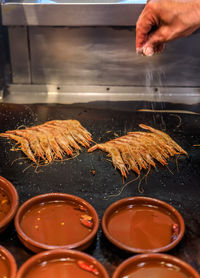 Cropped hand of person preparing food on table