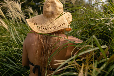 Rear view of woman standing amidst plants