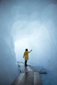 Rear view of woman standing in snow cave