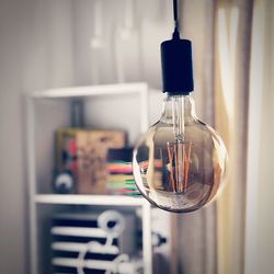 Close-up of light bulb hanging at home