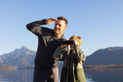 Father and son enjoying by lake