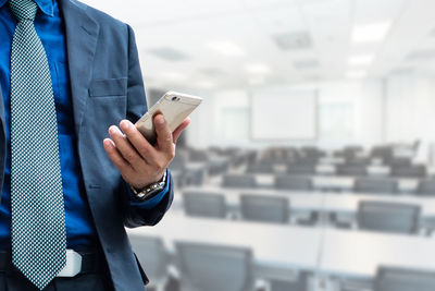 Midsection of man using mobile phone