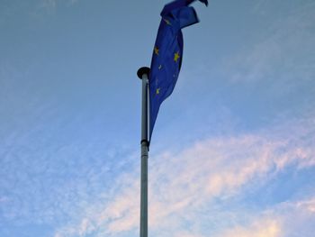 Low angle view of flag against blue sky