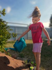 Girl playing on land against sky